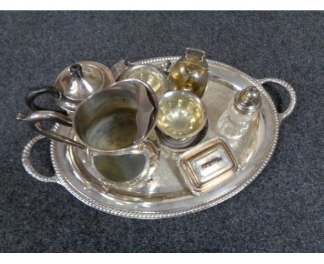 A tray of twentieth century plated wares, twin handled serving tray, three piece tea service, sugar sifter, wine coasters etc