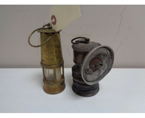 A vintage premiere carbide lamp together with a miniature brass Eccles protector miner's lamp 