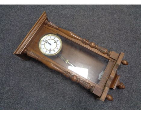 A 20th century oak cased Hermle wall clock with brass and enamelled dial, pendulum and key 