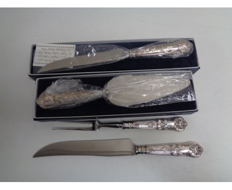 A boxed silver handled bread knife and cake slice, together with a further silver handled carving knife &amp; fork. (4)