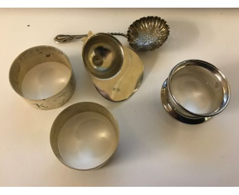 Three HM silver napkin rings, straining spoon and jockey cap tea caddy spoon