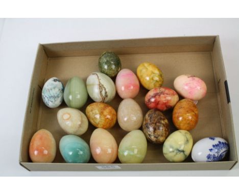 A collection of nineteen caved stone and ceramic ornamental eggs. 