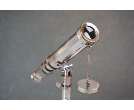 Brass cased telescope on a tripod base 