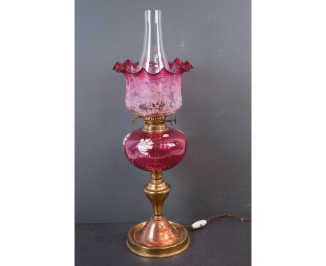 A brass lamp with graduated cranberry shade.