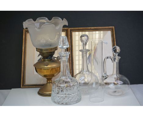 A box of mixed collectables to include a brass oil lamp, three glass decanters and two framed pictures. 