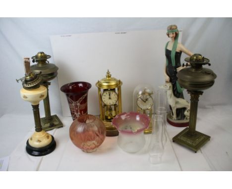 A collection of brass and ceramic oil lamps together with a large resin Art Deco style figure. 