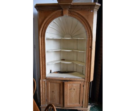 A Country House pine open corner display cabinet, dentil cornice above an arched painted niche moulded and applied with a sun