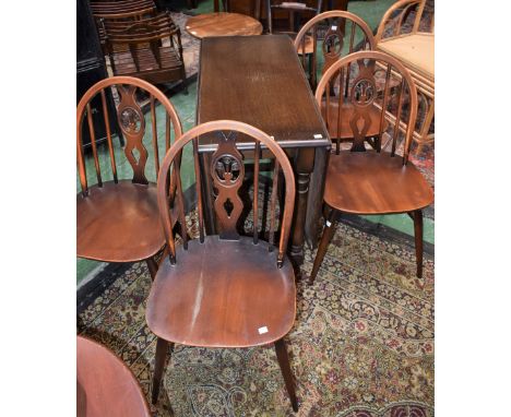 An early-mid 20th century oak dropleaf dining table; a set of four Ercol elm dining chairs (5)