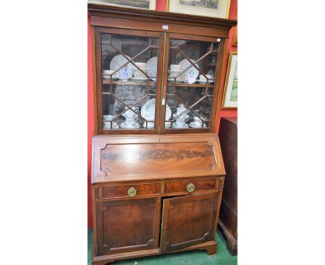 A George III style mahogany bureau bookcase, outswept cornice above a pair of astragal glazed doors enclosing a shelf, the ba