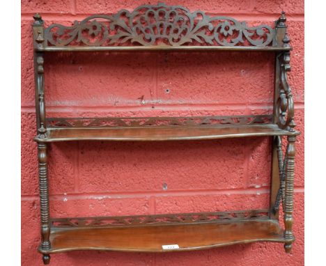 An early 20th century mahogany wall hanging shelf, of small proportions, crested by a pierced gallery and turned urnular fini