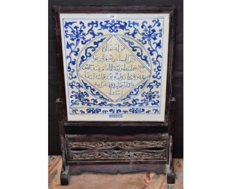 A Chinese blue and white ceramic table screen, carved hardwood frame and stand, 82.5cm high