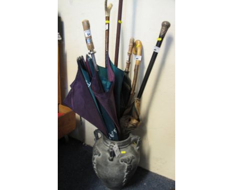 Ceramic stick stand together with a collection of assorted walking sticks and umbrellas, various.