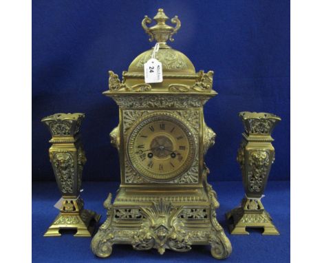 French brass mantel clock garniture of Classical design with scrolled foliate and mask mounts, two train French movement stri