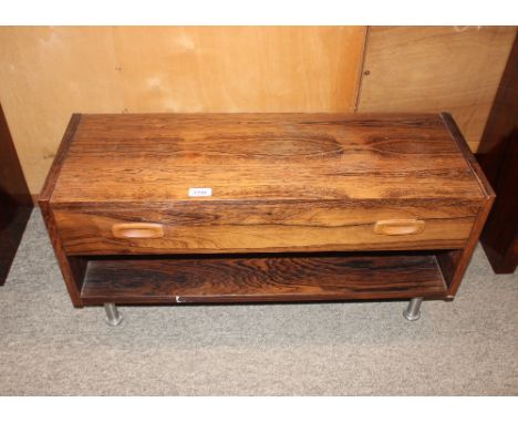 A simulated rosewood low cabinet fitted single drawer and open shelf, raised on metal supports, 80cm wide x 28.5cm deep x 38c