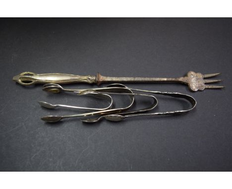 Four various pairs of silver sugar tongs and an Arts & Crafts pickle fork.