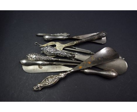 Twelve various silver handled button hooks, shoe horns and similar.