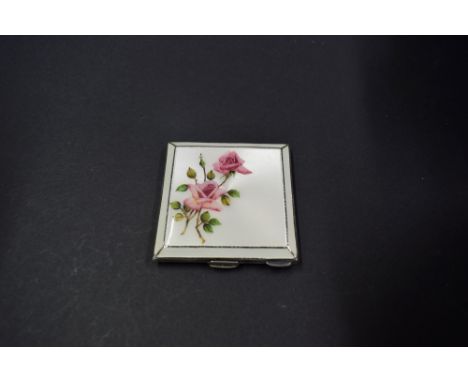 A silver compact, by Henry Clifford Davis, Birmingham 1940, having engine turned and floral enamel decoration, 7 x 7cm.