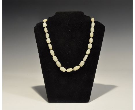 "20th century AD. A necklace of facetted milky jade beads with biconical glass spacers, screw closures. 63 grams, 53cm (21").