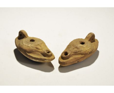"20th century AD. A pair of ceramic oil lamps, each a slipper-shaped body, raised lug handle, broad discus, bearded face abov