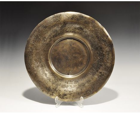 19th-20th century AD. A bronze discoid tray with central recess, broad flange rim with incised bands of calligraphic text. 54
