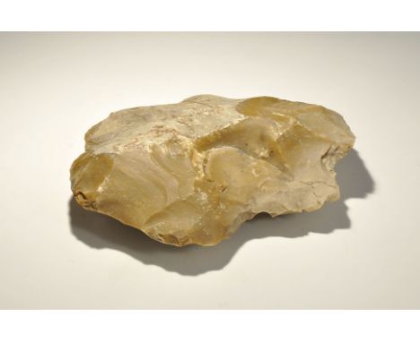 "Circa 3000 BC. A very large and heavy knapped cleaver with trimmed at edges, in the classic opaque yellow-brown flint; showi