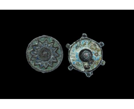 "2nd century AD. A group of cast bronze disc brooches comprising: one with radiating zigzag and pellets, enamelled field, cat