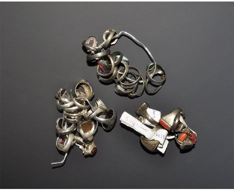 "20th century AD. A mixed group of silver-coloured metal finger rings of various types, each with an inset plaque of coral, g