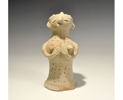 "20th century AD. A bell-shaped ceramic figurine with globular head; applied arms supporting the breasts, applied facial deta