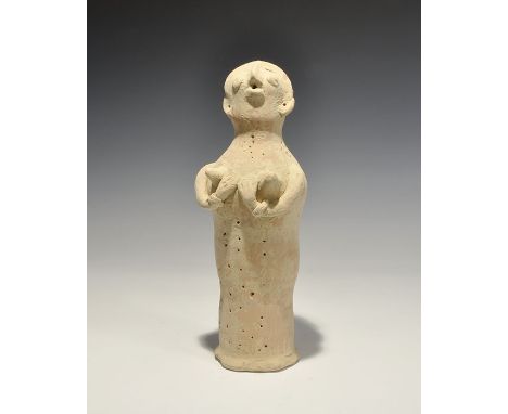 "3300-1700 BC. A tubular ceramic figurine with globular head; applied arms supporting the breasts, applied facial details, li