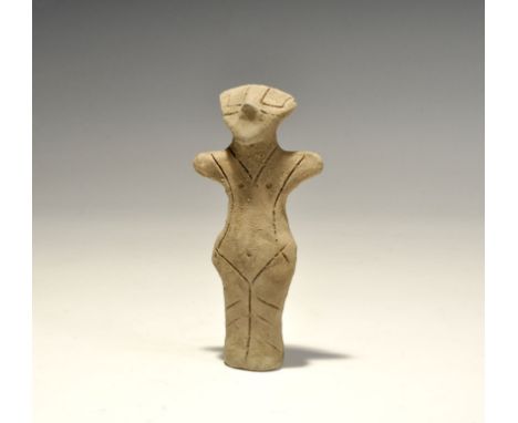 "5th-4th millennium BC. A terracotta figurine with pinched facial features, stub arms and conjoined legs; linear detailing fo