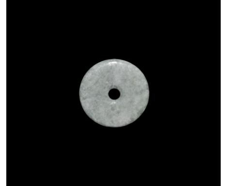 "20th century AD. A green jade circular pendant with hole to the middle. 29 grams, 49mm (2"). Acquired on the London art mark
