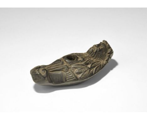 "19th century AD. A carved basalt lamp with flat base, keeled sides, domed upper face; the handle formed as a bearded male fa