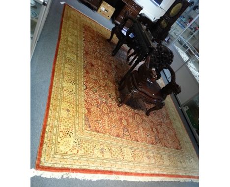 A Persian carpet, the madder field with allover palmettes, acanthus and floral spray design, a rosette and mini floral border