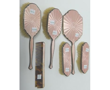 A lady's silver and pale pink enamel mounted six piece dressing set, comprising; a hand mirror, a pair of clothes brushes, a 