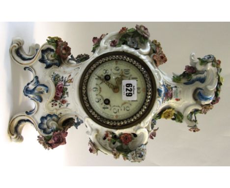 A Continental porcelain mantel clock, the porcelain probably late 18th/early 19th century, the relief scroll moulded body dec