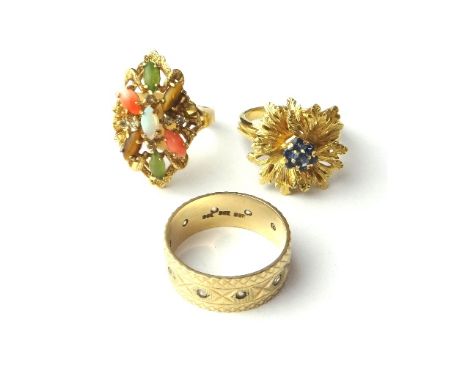 A gold and sapphire set seven stone cluster ring, with a flowerhead shaped motif, detailed 750, a gold and colourless gem set