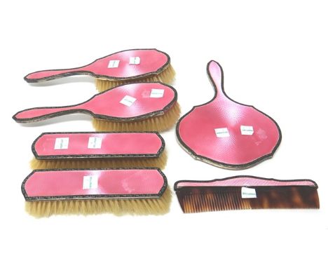 A lady's silver and pink enameled six piece dressing set, comprising; a hand mirror, a pair of clothes brushes, a pair of hai