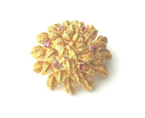 An 18ct gold and ruby set brooch, designed as a flowerhead, the central ruby lacking, but further set with six circular cut r