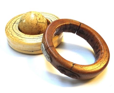 An 18th century carved ivory tusk bangle (a.f.) (10cm wide), a similar 19th century version and a carved ivory ball (3). 