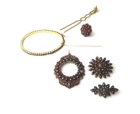 A group of Bohemian garnet set jewellery, comprising; an oval hinged bangle, a brooch, an oval pendant surround, with an open