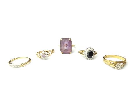 A 9ct gold ring, claw set with a cut cornered rectangular cut amethyst, a 9ct gold, sapphire and diamond set oval cluster rin