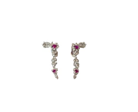 A pair of ruby and diamond set earclips, each in a cluster and foliate pendant drop design, claw set with two circular cut ru