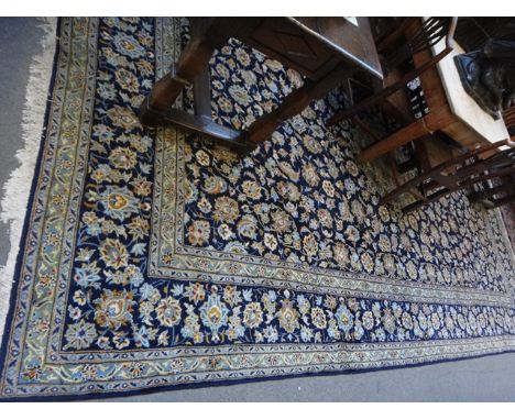 A Kashan carpet, Persian, the dark indigo field with a pale central rosette medallion, all with trailing floral and leaf spra