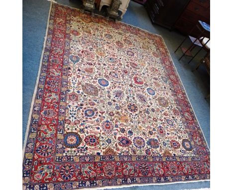 A Tabriz carpet, Persian, the beige field with an allover palmette and floral spray design, a madder complementary border, 30