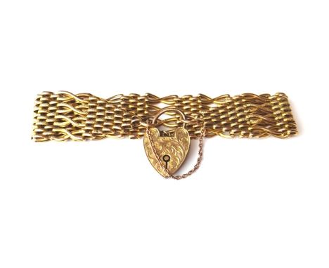 A gold crossover bar and oval link wide gate bracelet, detailed 9ct, on a gold heart shaped padlock clasp, with feathered scr