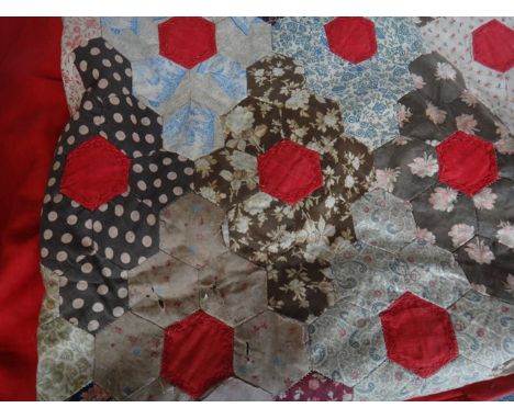 A patchwork double bed spread, early 20th century, sewn against a red ground, 320cm x 280cm.