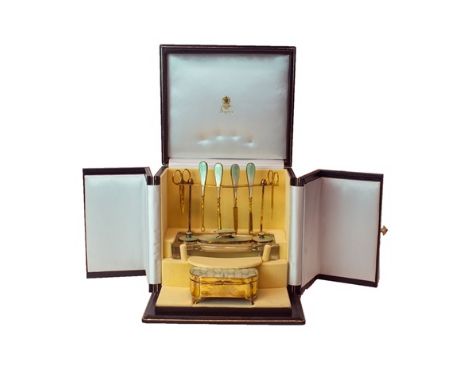 A lady's silver gilt and enameled dressing table set, comprising; a shaped rectangular hinge lidded trinket box and a manicur