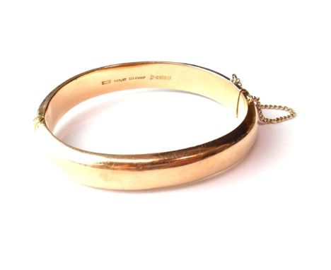 A 9ct plain rose gold oval hinged bangle, on a snap clasp, with a safety chain, Chester 1916, weight 18 gms.