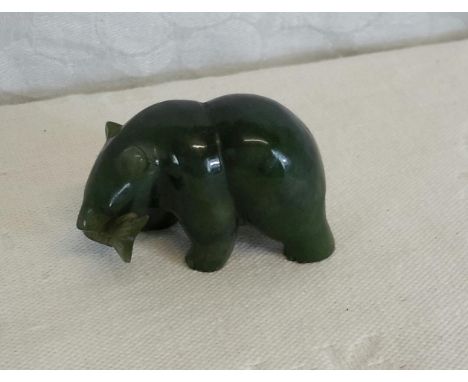 A jade figurine of a bear holding a fish in its mouth, 3cmx5cm 