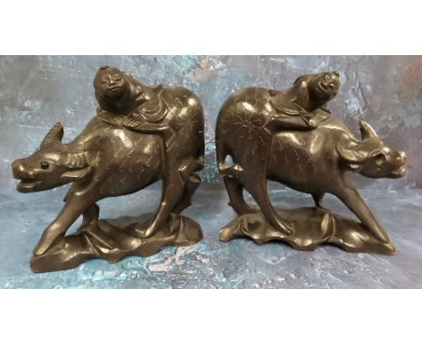 Chinese School, early 20th century, a pair of hardwood carvings, Boy on a Buffalo, applied with silver wire, 19cm high 